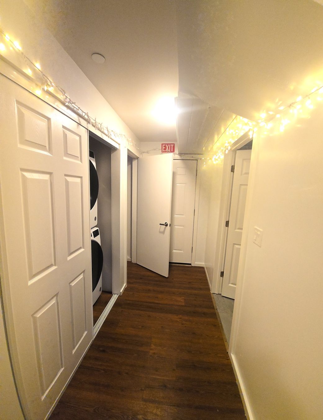 Hallway with on-site laundry and a marked emergency exit